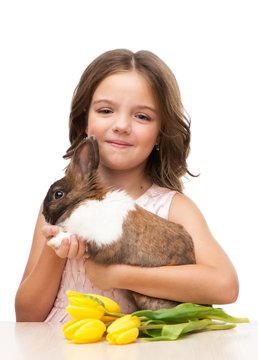 Little girl holding bunny and tulips
