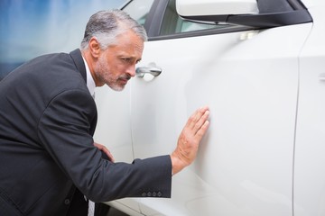 Fototapeta premium Focused businessman looking at the car body