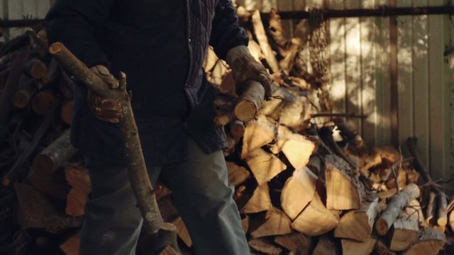 Man chopping firewood with circular saw. Slow motion