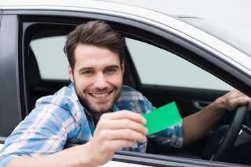 Young man smiling at camera showing card