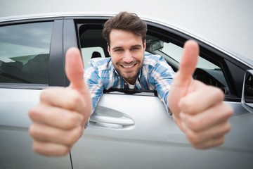 Young man smiling at camera showing thumbs up