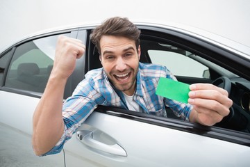 Young man smiling and holding card