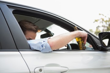 Naklejka premium Man drinking beer while driving