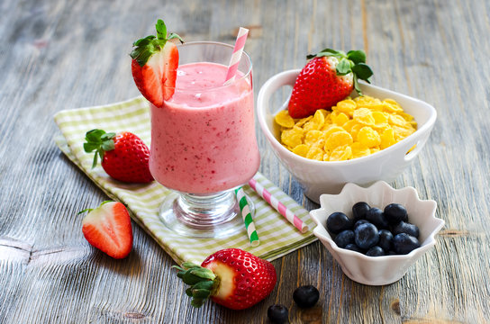 Healthy breakfast with cornflakes, strawberry smoothie and blueb