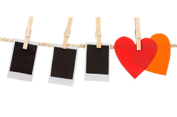 instant photographs and heart shapes hanging on a rope