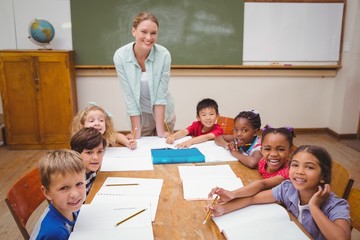 Teacher and pupils working at desk together