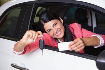 Smiling woman holding car key and business card