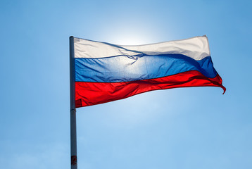 Naklejka na ściany i meble Russian flag waving in the wind over blue sky