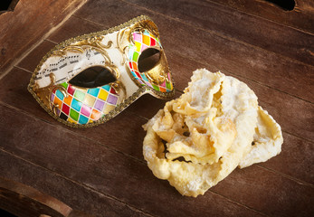 Fried pastry of italian carnival with venetian mask.