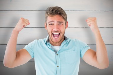 Composite image of handsome young man cheering at camera