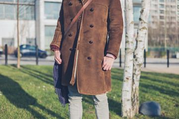 Woman in warm coat by birch trees