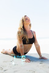 Composite image of fit blonde in cobra pose on the beach