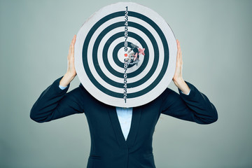 Business woman hold target in front of face.