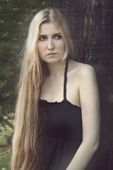 Fototapeta premium thoughtful woman standing under the burnt tree