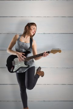 Composite image of pretty young girl playing her guitar