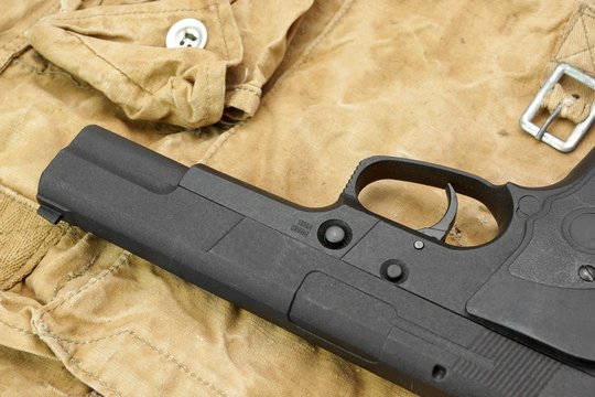 Handgun Lying Over a  Camouflage  Handbag