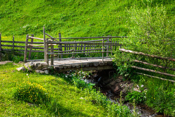 wooden bridge over narrow stream