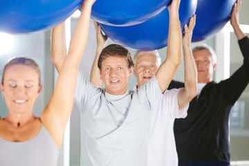 Mann in Gruppe bei Fitnesstraining mit Gymnastikball
