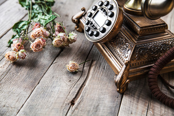 Old vintage black rotary phone and a bouquet of roses - 78335016
