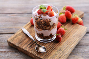 Healthy layered dessert with muesli and berries on table