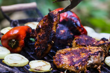 Steak, sausage, onion, red pepper and toast on a BBQ