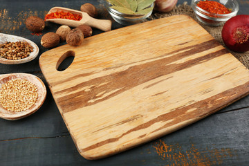 Different spices and herbs with cutting board