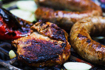 Steak, sausage, onion, red pepper and toast on a BBQ