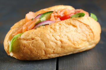 Sandwich with salmon on wooden background