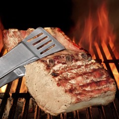 Tongs Holding Grilled Pork Ribs