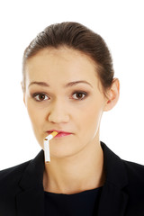 Businesswoman with broke cigarette in mouth.