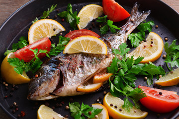 Tasty baked fish on table close-up