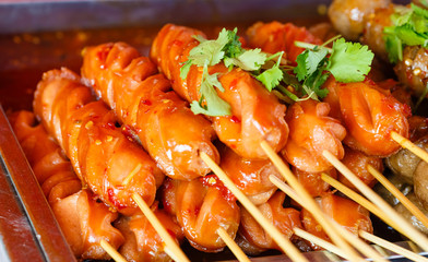 Fried sausage a grill on a stick in sauce