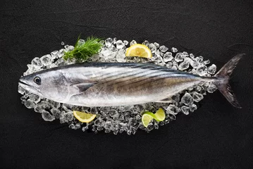 Crédence de cuisine en verre imprimé Poisson Tuna fish on ice on a black stone table top view