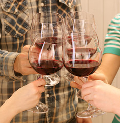 Clinking glasses of red wine in hands
