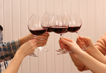 Clinking glasses of red wine in hands