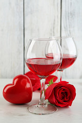 Composition with red wine in glass, red roses and decorative