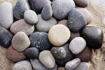 Fototapeta na wymiar Gray sea pebbles on sand background