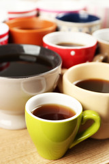 Many cups of coffee on wooden table background, closeup view