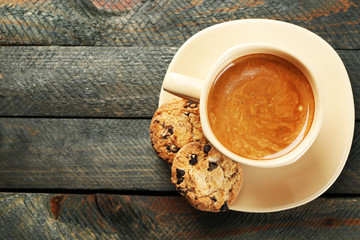 Cup of coffee and tasty cookies on wooden background