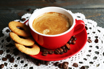 Cup of coffee and tasty cookies on wooden background