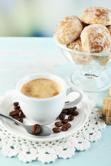 Cup of coffee and tasty cookie on color wooden background