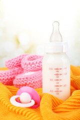 Baby milk bottle, pacifier and babys bootees