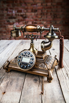 Old telephone on wooden background. Copy space on the bottom.