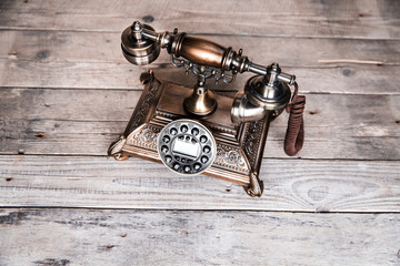 Old telephone on wooden background. Copy space on the bottom.