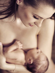 Young beautiful mom hugging her newborn child