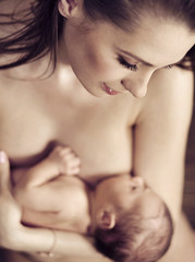 Fototapeta premium Young beautiful mom hugging her newborn child
