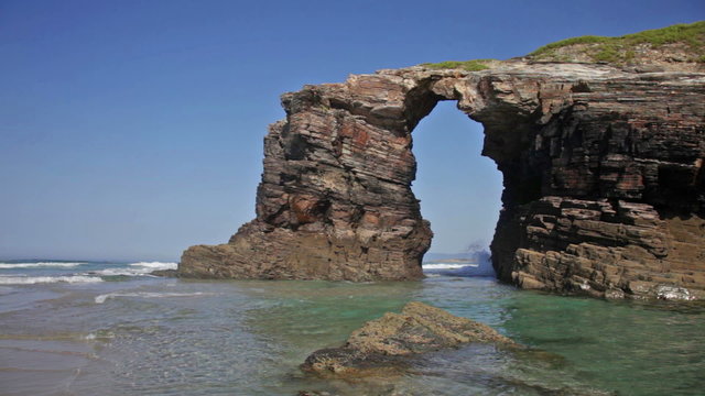 Stone arches on Playa de las Catedrales during outflow, Spain