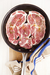 raw beefsteak with seasoning & olive oil in pan. wooden bord. on