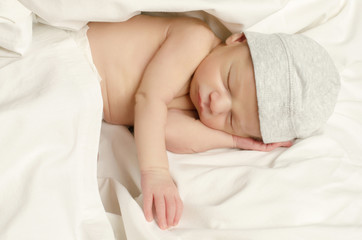 Fototapeta na wymiar New born baby boy with cute gray hat sleeping taking a nap.