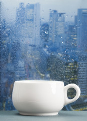 Coffee cup on a rainy day in front of the window